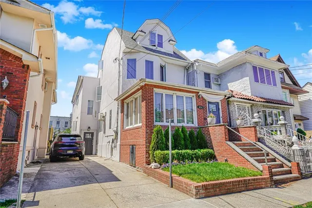 a front view of a residential apartment building with a yard