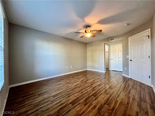 a view of an empty room window and wooden floor