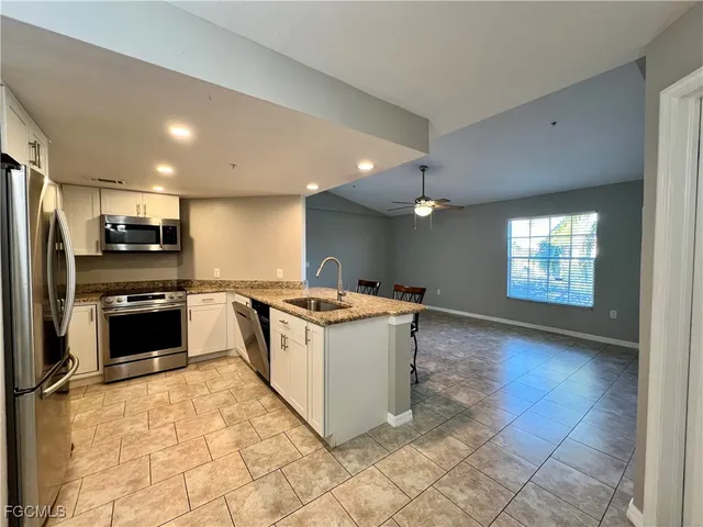 a large kitchen with a stove a refrigerator and a sink