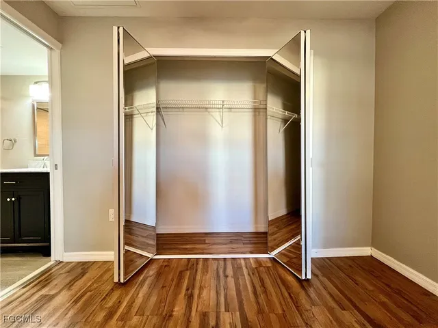 an empty room with wooden floor and cabinet