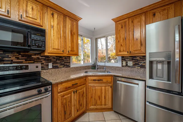 a kitchen with stainless steel appliances granite countertop a refrigerator and a stove top oven