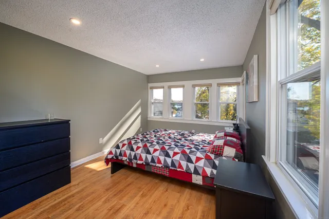 a bedroom with a bed and wooden floor