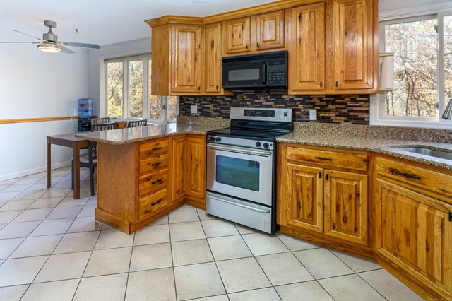 a kitchen with stainless steel appliances granite countertop a stove a sink and a microwave