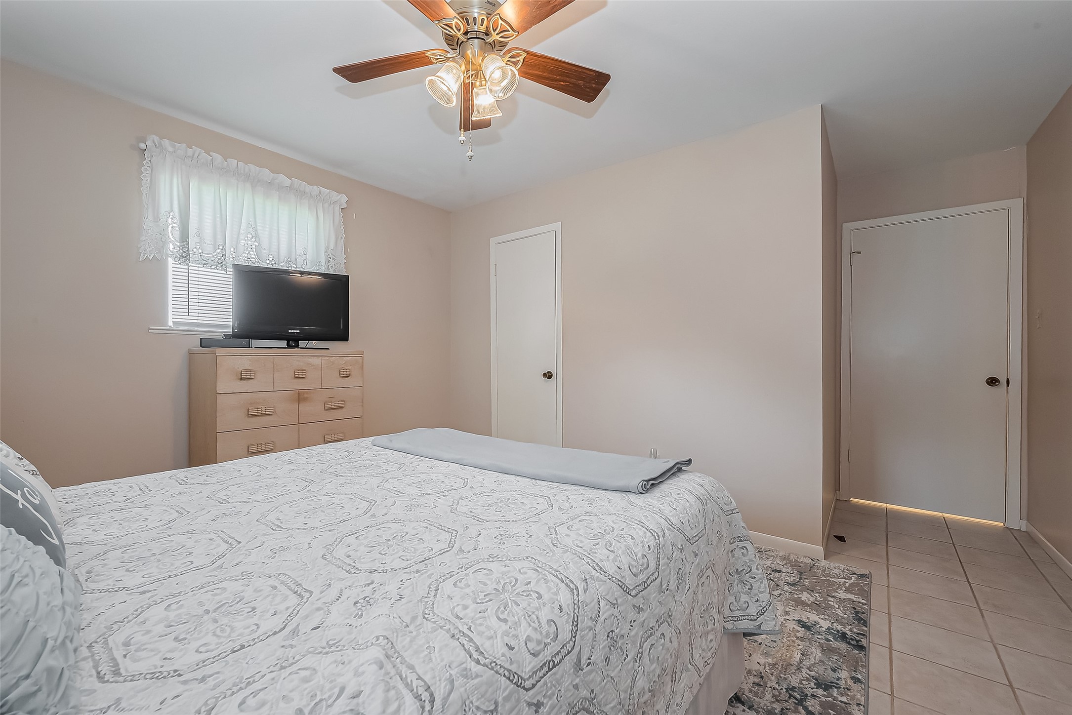 9214 Church Street Needville, TX 77461 - Photo 32 of 44 a bedroom with a bed and a flat tv screen on a dresser
