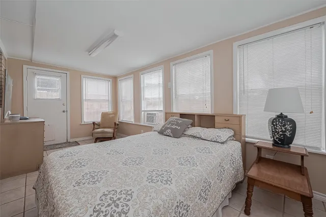 a bedroom with a bed a large window and chair