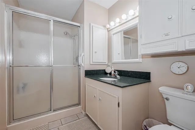 a bathroom with a granite countertop sink mirror vanity and toilet