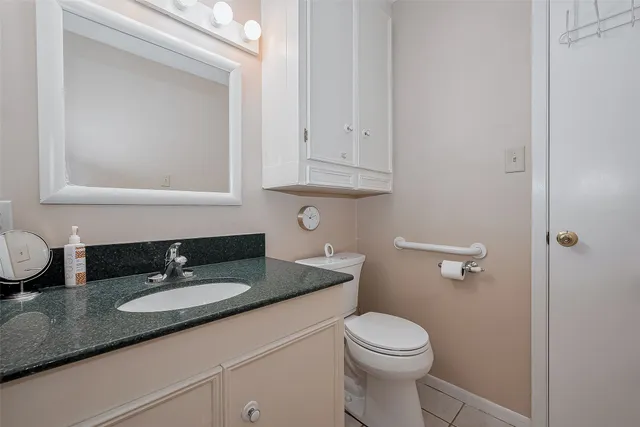 a bathroom with a granite countertop sink a toilet and a mirror