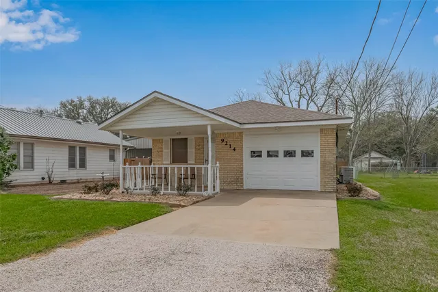 a front view of a house with a garden and yard