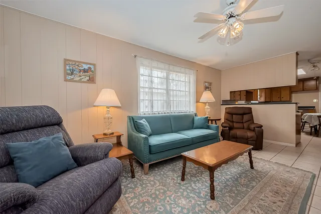 a living room with furniture a chandelier and a window