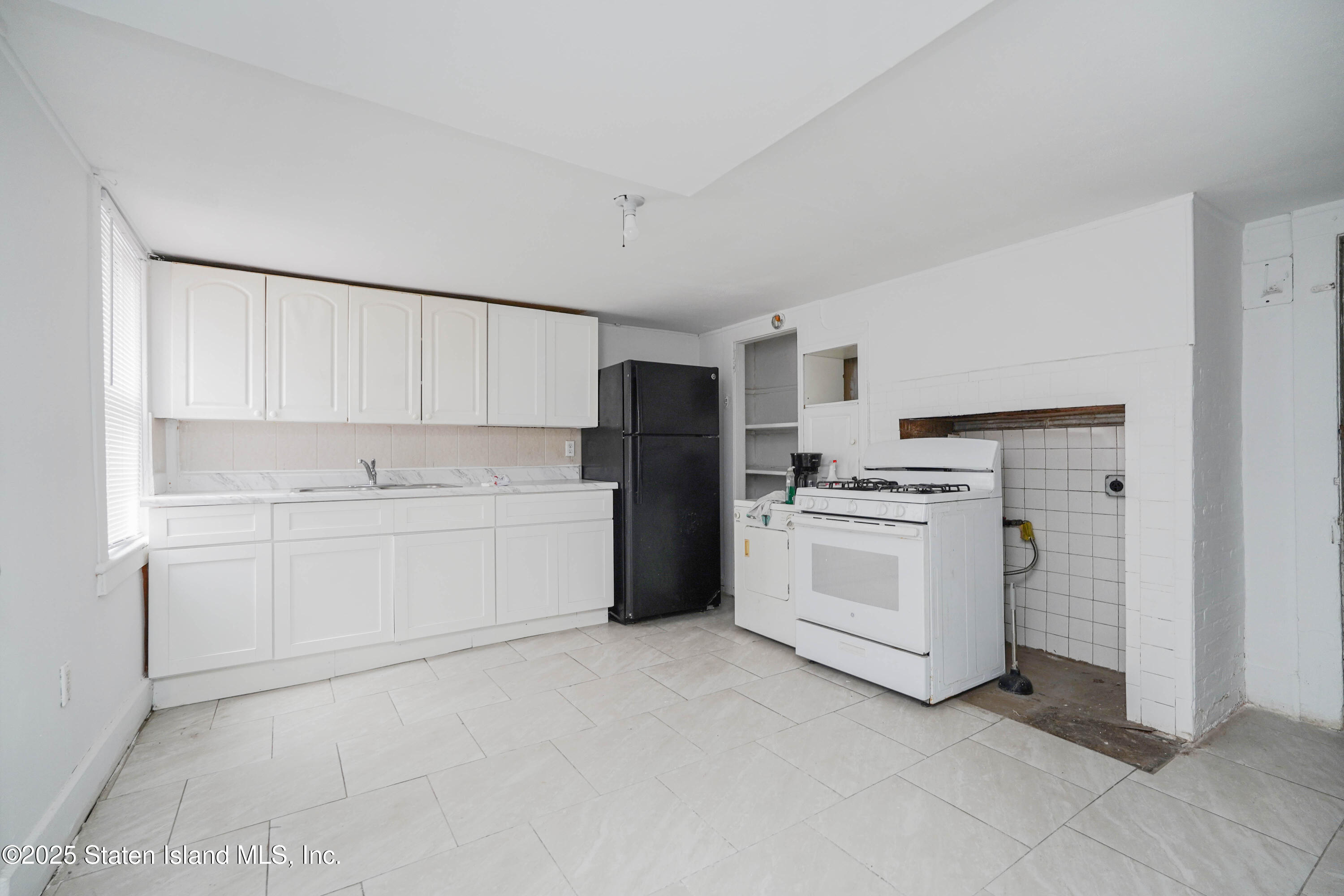 40 Larkin Street Staten Island, NY 10302 - Photo 11 of 36 a kitchen with white cabinets and white appliances