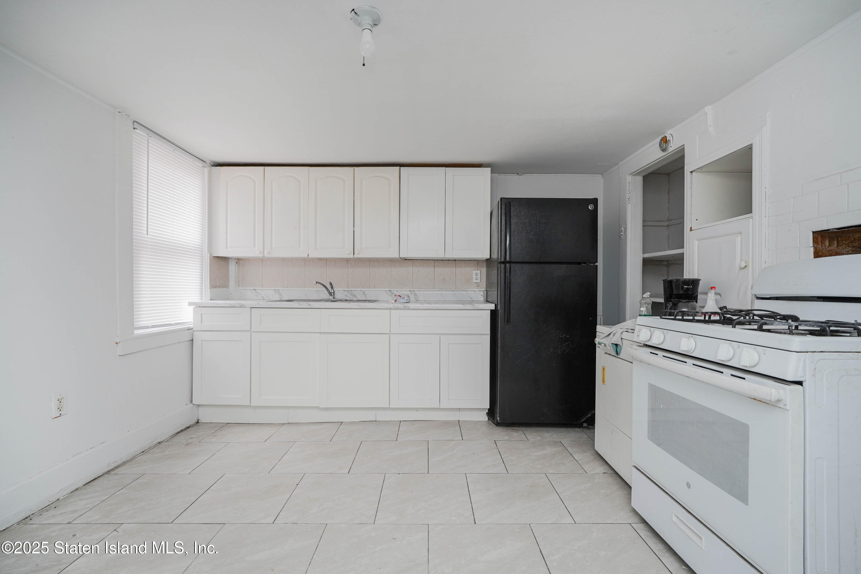 40 Larkin Street Staten Island, NY 10302 - Photo 12 of 36 a kitchen with a stove a sink and a refrigerator