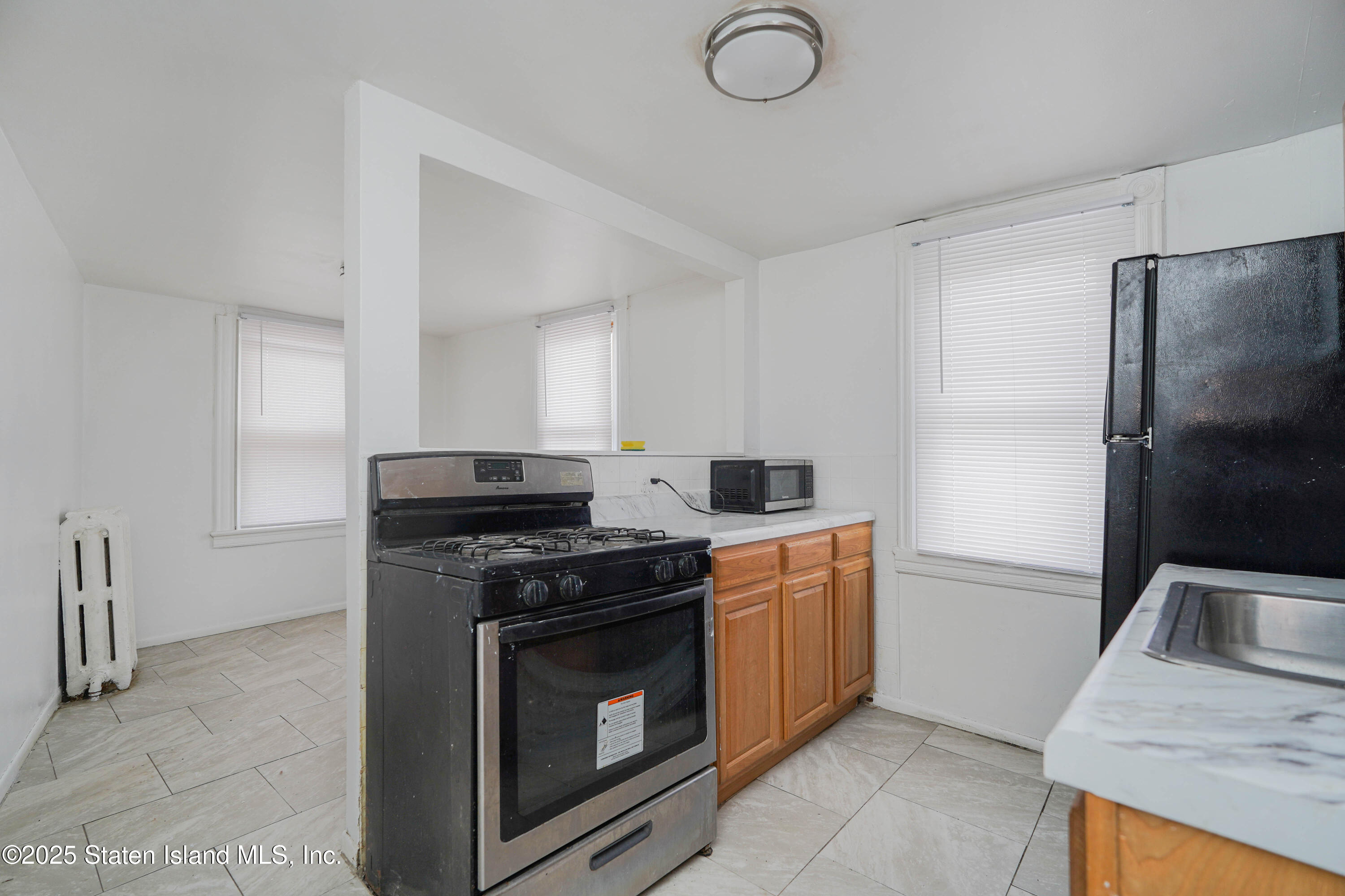 40 Larkin Street Staten Island, NY 10302 - Photo 14 of 36 a kitchen with stainless steel appliances granite countertop a stove a refrigerator and a sink