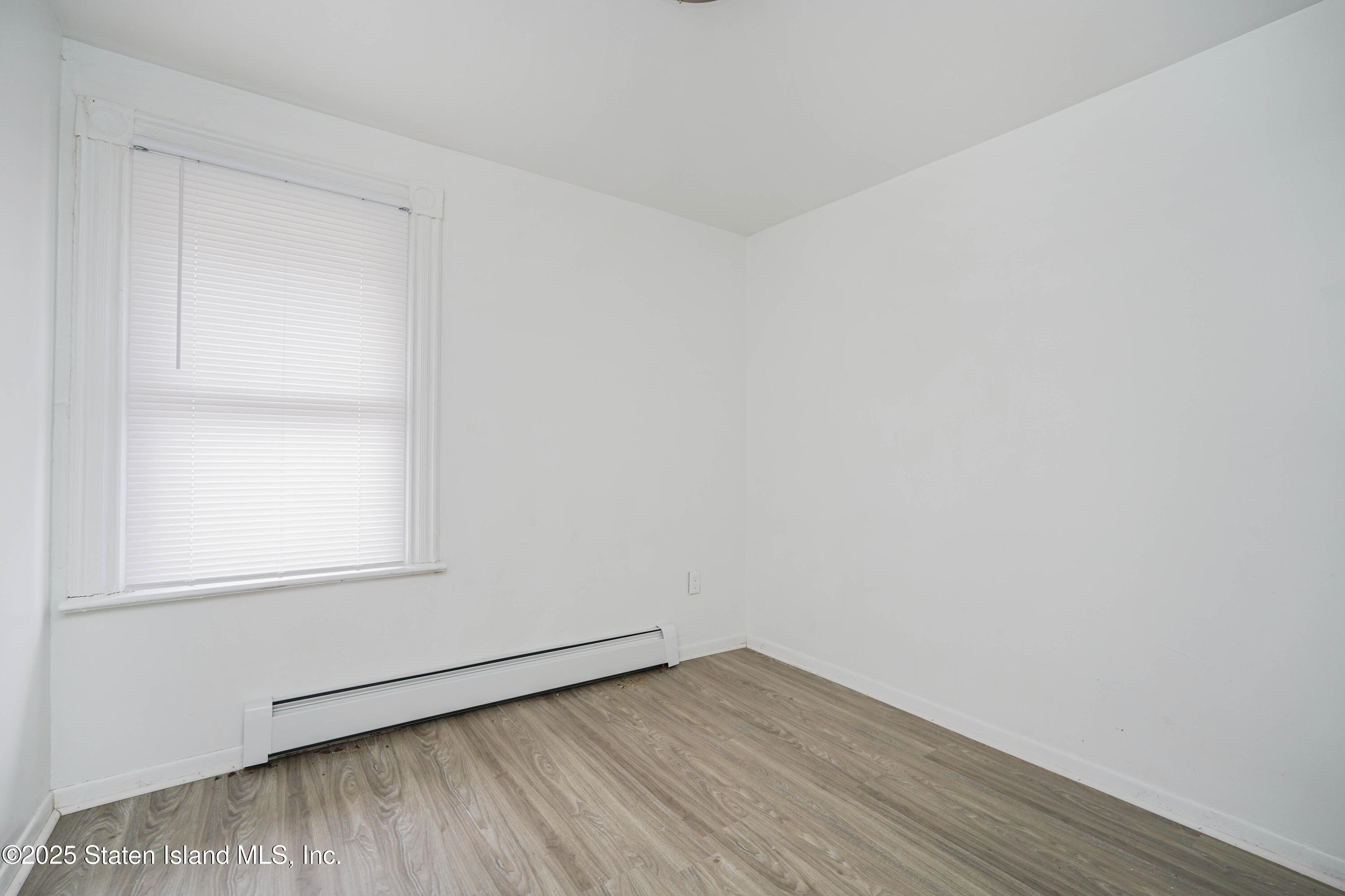 40 Larkin Street Staten Island, NY 10302 - Photo 24 of 36 a view of an empty room with wooden floor and a window