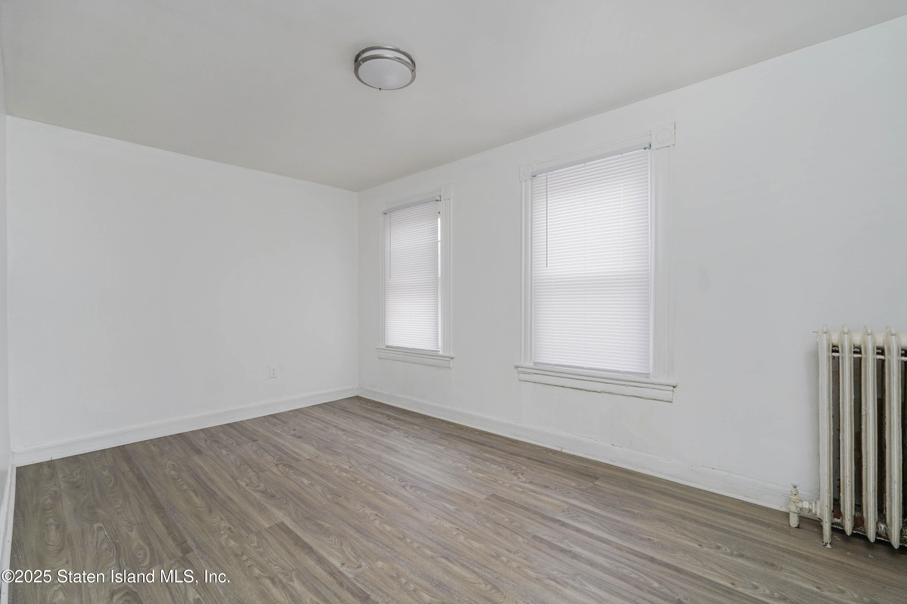 40 Larkin Street Staten Island, NY 10302 - Photo 25 of 36 an empty room with wooden floor and window