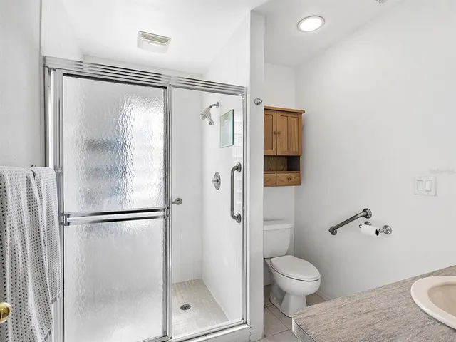 a bathroom with a toilet shower and a glass door