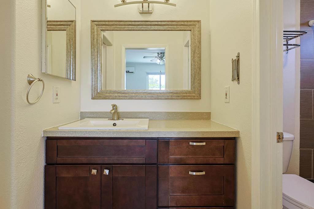 488 D Street Chula Vista, CA 91910 - Photo 12 of 25 a bathroom with a granite countertop sink a toilet and a mirror