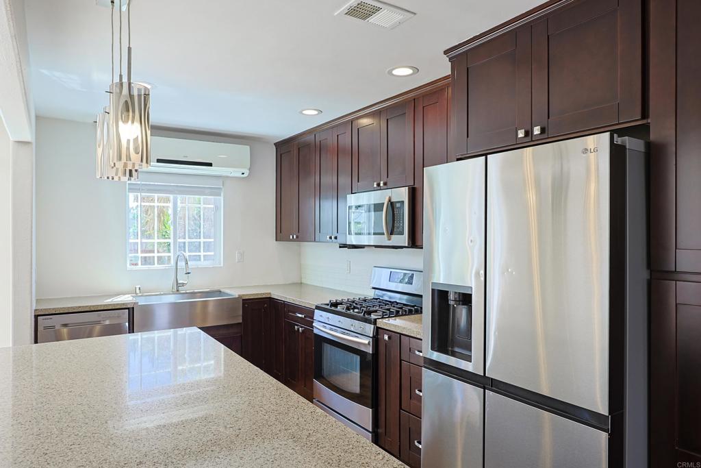 488 D Street Chula Vista, CA 91910 - Photo 5 of 25 a kitchen with stainless steel appliances granite countertop a refrigerator a sink dishwasher a stove and a refrigerator with wooden floor