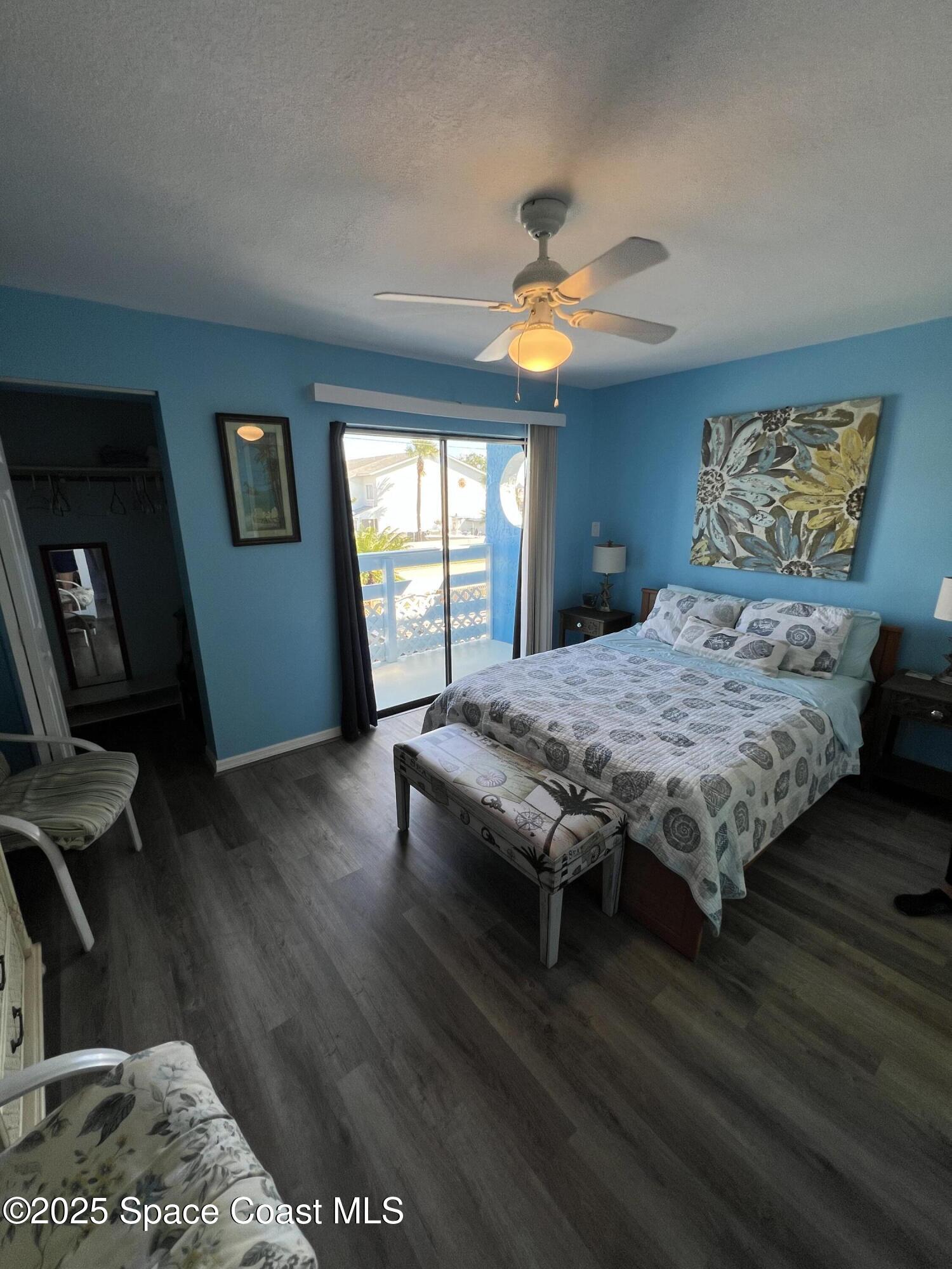 299 Chandler Street, Unit F Cape Canaveral, FL 32920 - Photo 11 of 26 a bedroom with a bed window and wooden floor