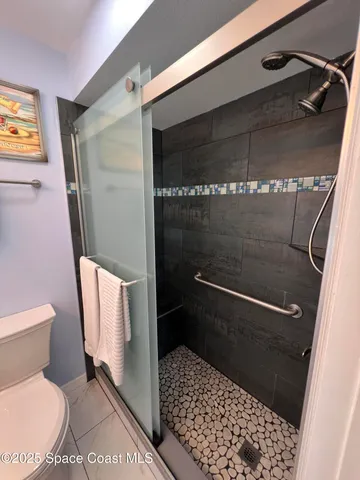 a bathroom with a toilet and a shower
