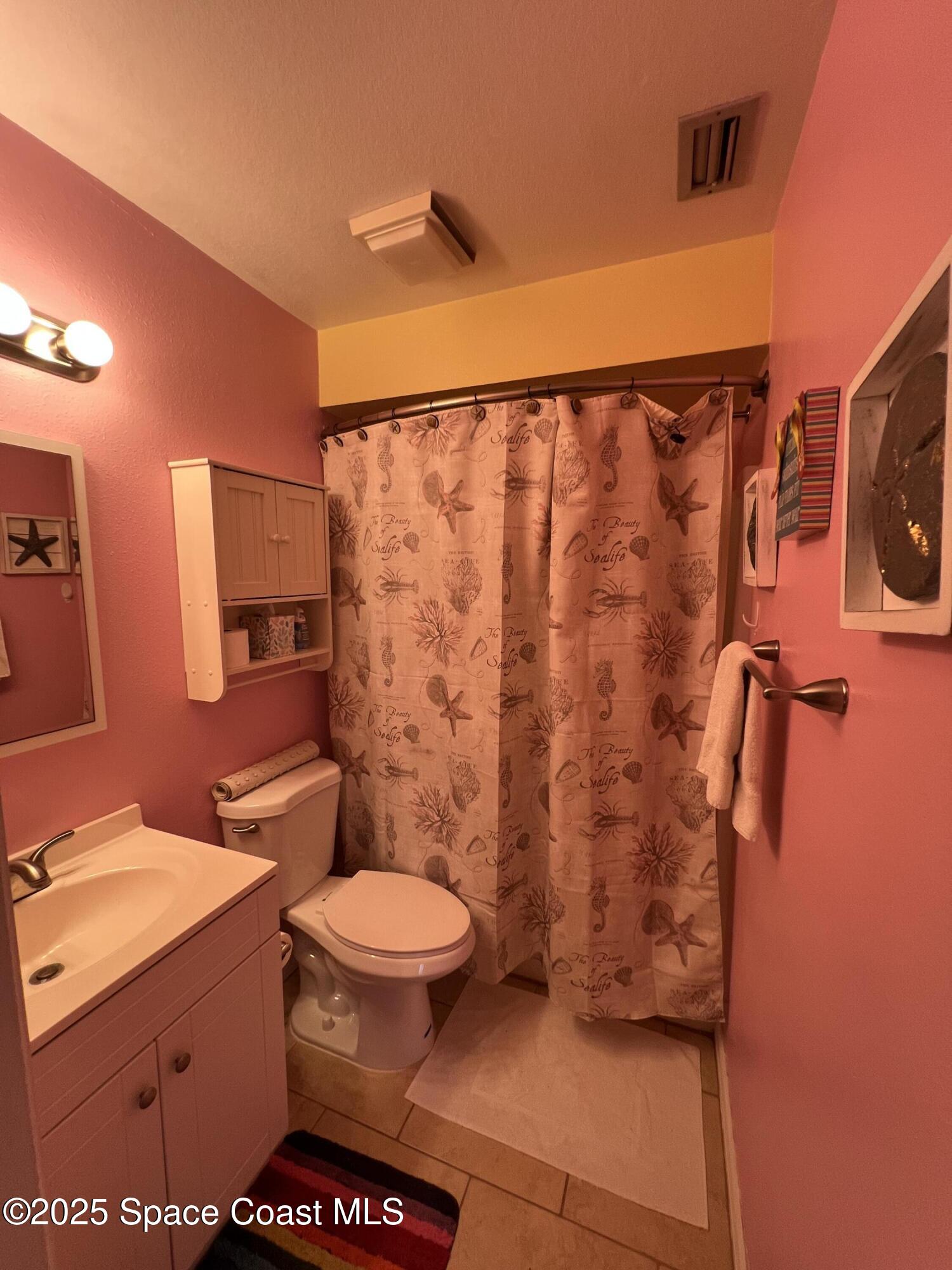 299 Chandler Street, Unit F Cape Canaveral, FL 32920 - Photo 14 of 26 a bathroom with a toilet and a shower