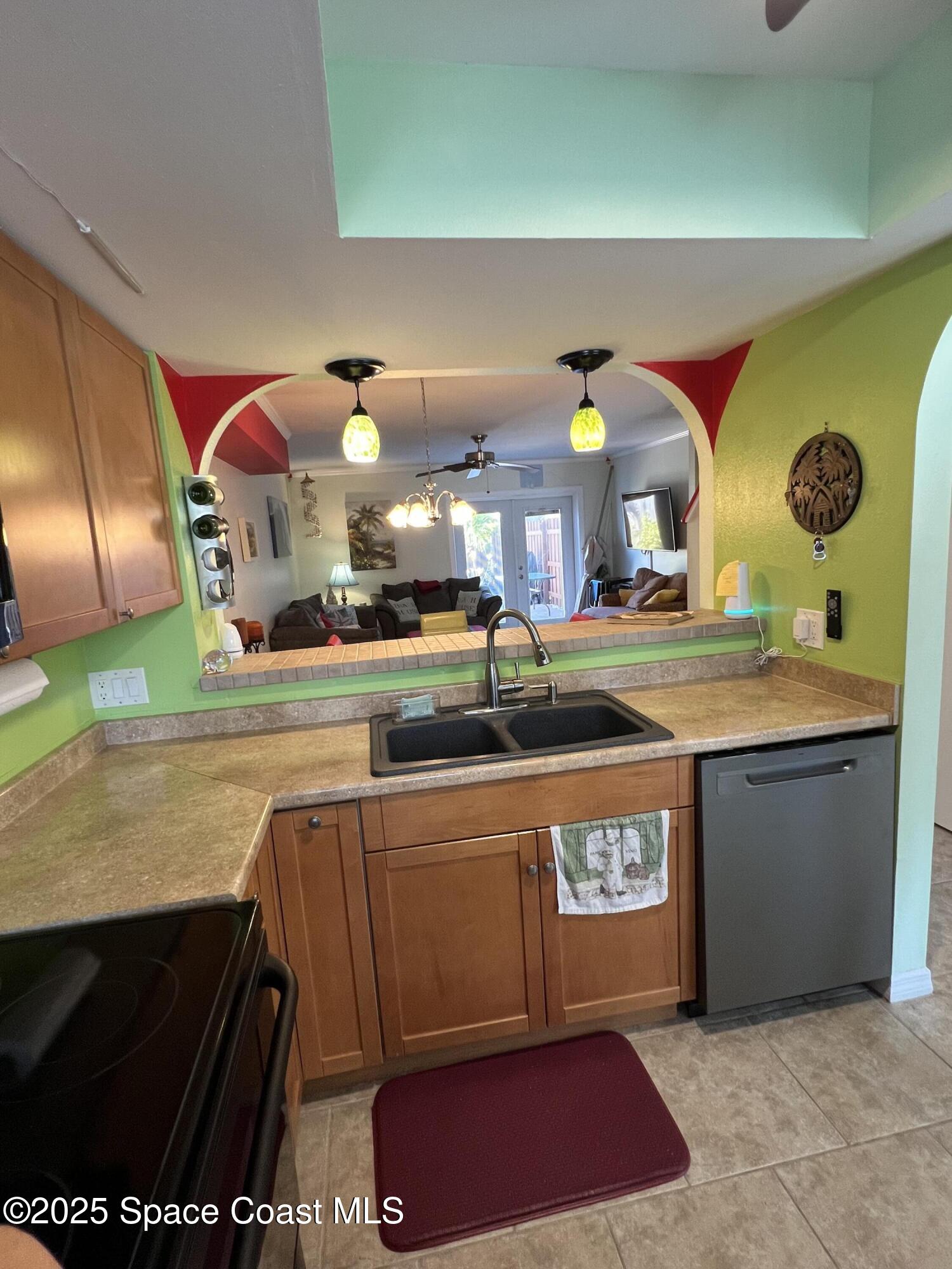 299 Chandler Street, Unit F Cape Canaveral, FL 32920 - Photo 5 of 26 a kitchen with stainless steel appliances granite countertop a stove a sink and a microwave