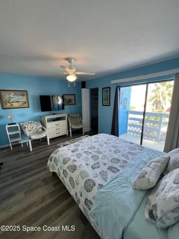 a bedroom with a large bed and a flat tv screen