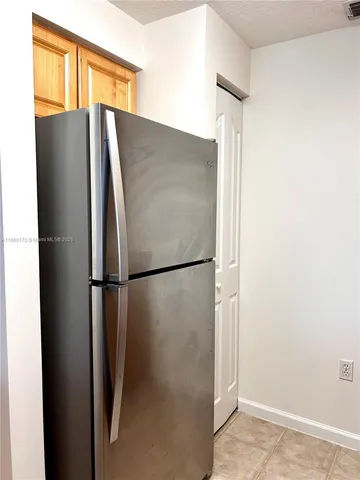 a metallic refrigerator freezer sitting in a kitchen