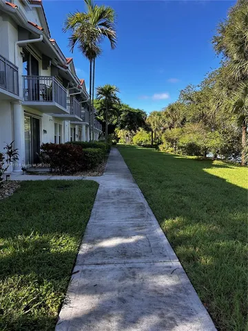 a front view of a house with a yard and potted plants