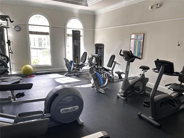 a room with gym equipment and wooden floor