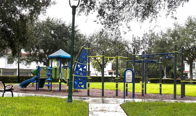 a view of swimming pool with lawn chairs and plants