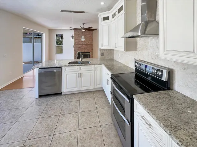 a kitchen with stainless steel appliances granite countertop a sink and a refrigerator