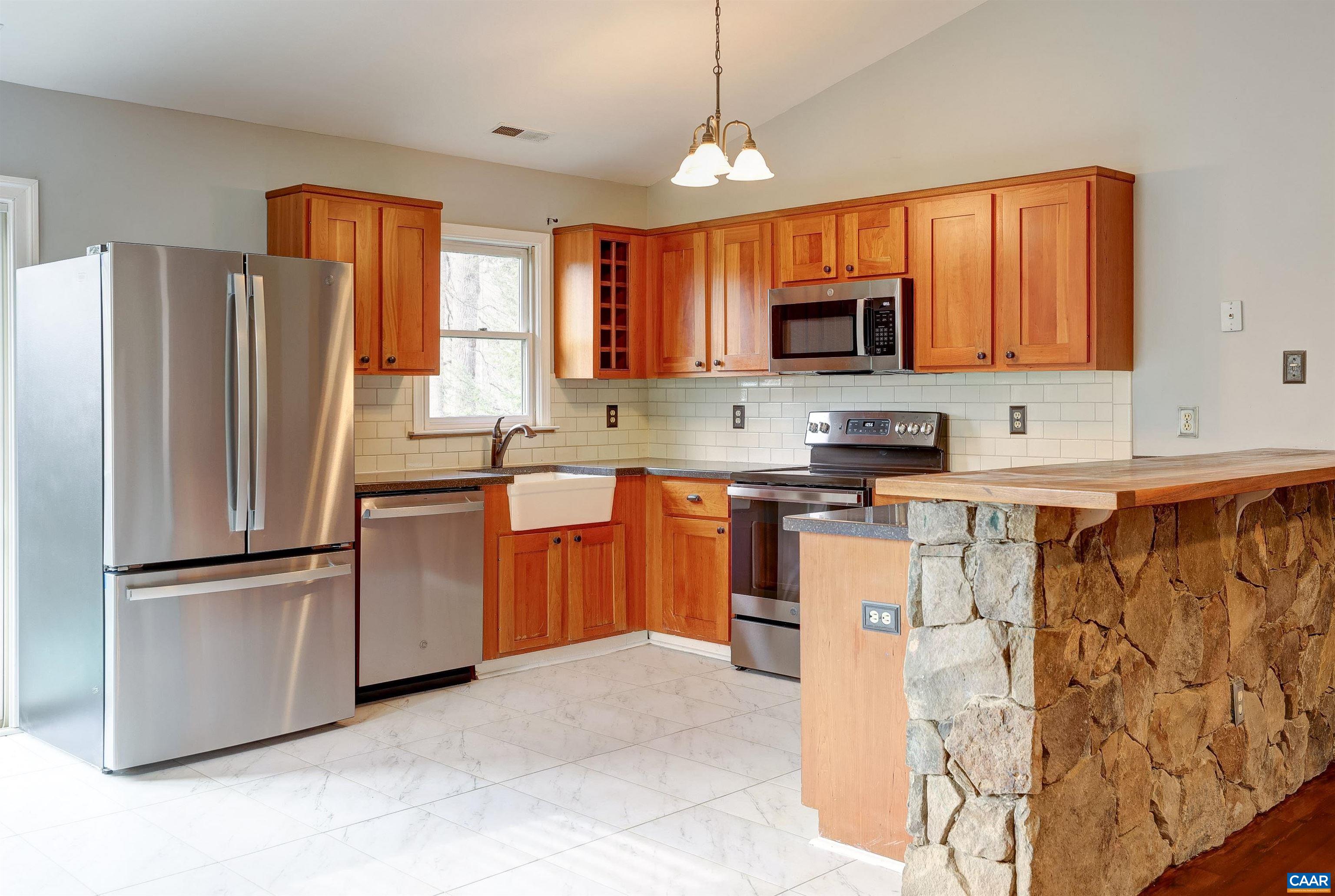 1086 West Daffodil Road Ruckersville, VA 22968 - Photo 4 of 33 a kitchen with stainless steel appliances granite countertop a refrigerator stove a sink and a microwave