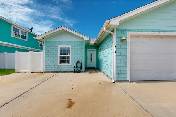 a view of yellow house with garage
