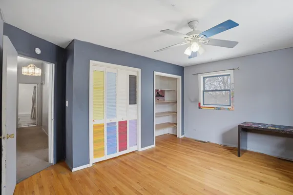 a view of a bedroom with wooden floor and closet