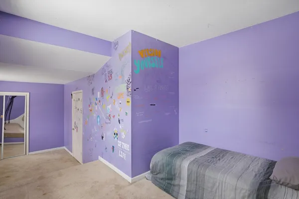 a bedroom with a bed and a painting on the wall