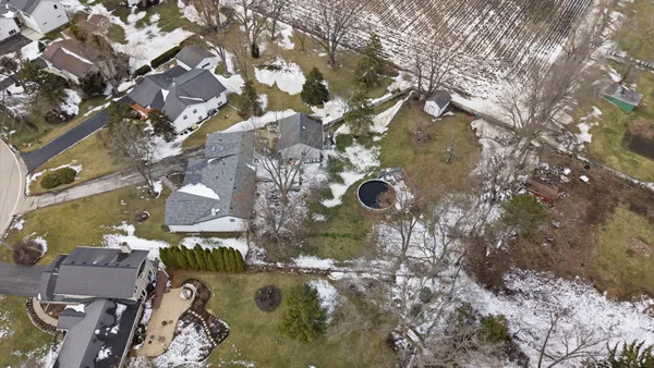 an aerial view of residential houses with yard