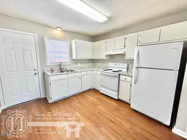a kitchen with white cabinets and white appliances