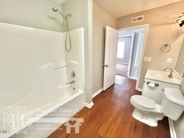 a bathroom with a tub shower sink and toilet