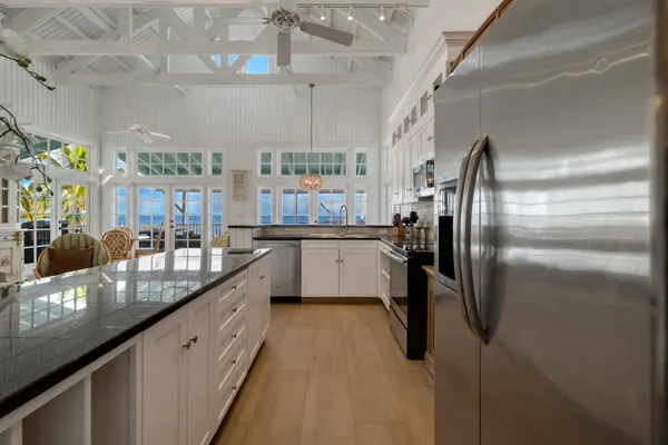 a kitchen with stainless steel appliances granite countertop a sink a stove and a wooden cabinets