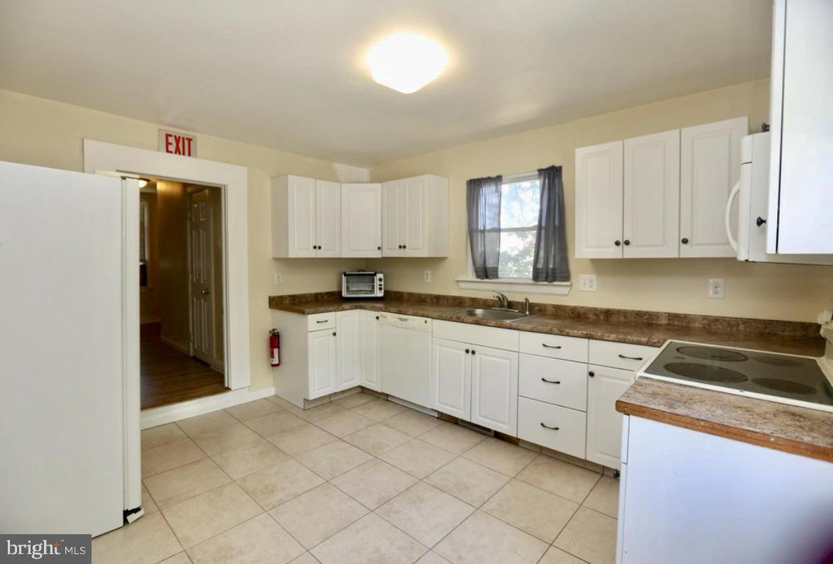 310 Ellis Street Glassboro, NJ 08028 - Photo 2 of 15 a kitchen with granite countertop white cabinets and refrigerator