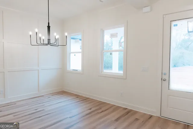 a view of empty room with wooden floor and window