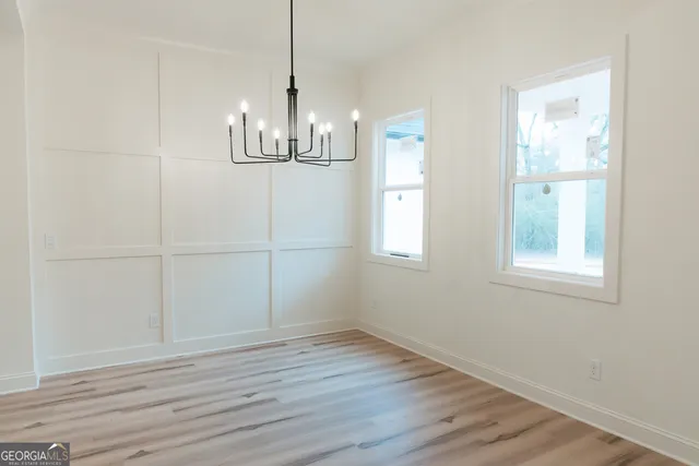 a view of empty room with wooden floor and window