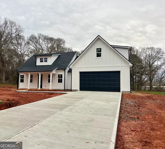 a front view of a house with yard and trees