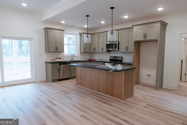 a kitchen with stainless steel appliances granite countertop a stove a sink and a refrigerator