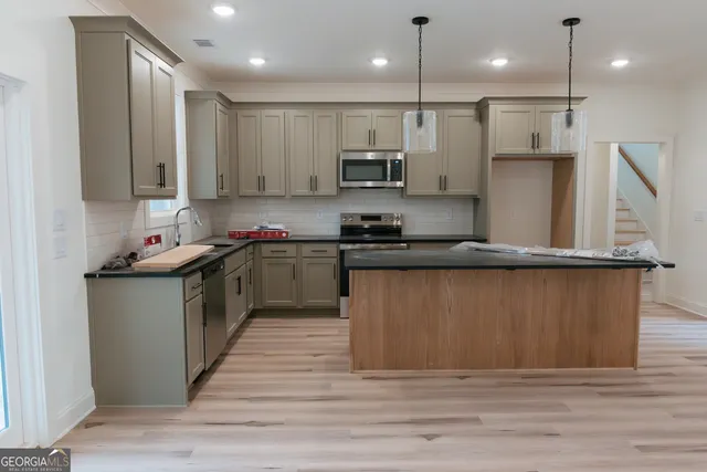 a kitchen with stainless steel appliances granite countertop a stove a sink dishwasher and a refrigerator