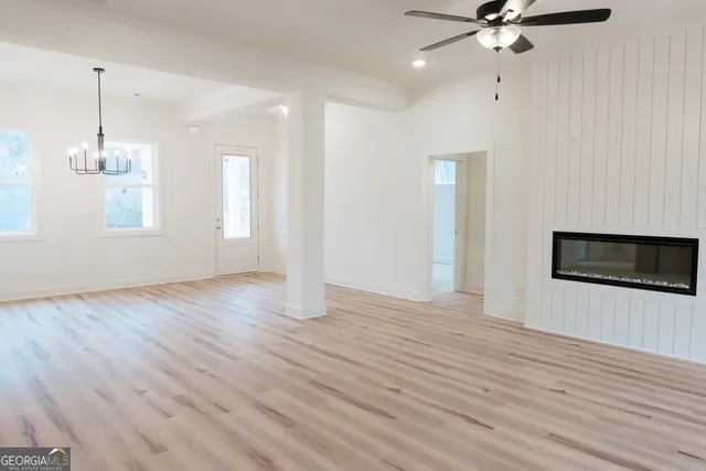 a view of a livingroom with a ceiling fan window and wooden floor