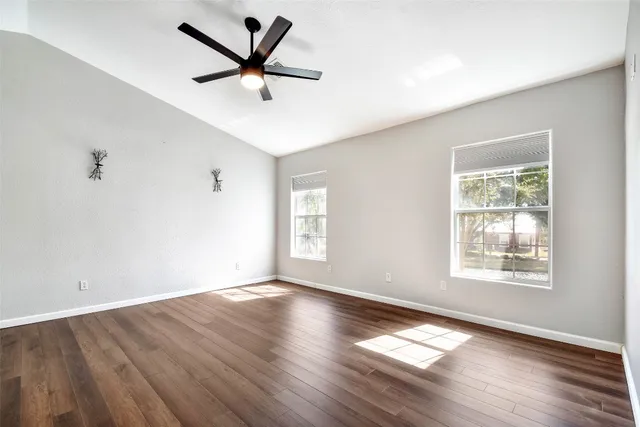a view of wooden floor and a chandelier fan in a room