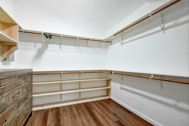 a view of walk in closet with empty racks
