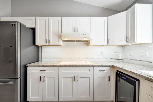 a kitchen with white cabinets and white appliances