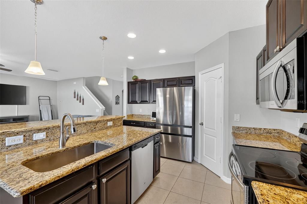 11214 Carrick Stone Street Wimauma, FL 33598 - Photo 22 of 73 a kitchen with a sink stove and refrigerator
